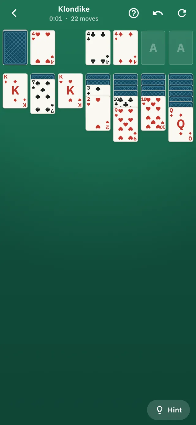 A game of Klondike solitaire in progress on the green felt table, with the stock, waste, and four foundation piles across the top.